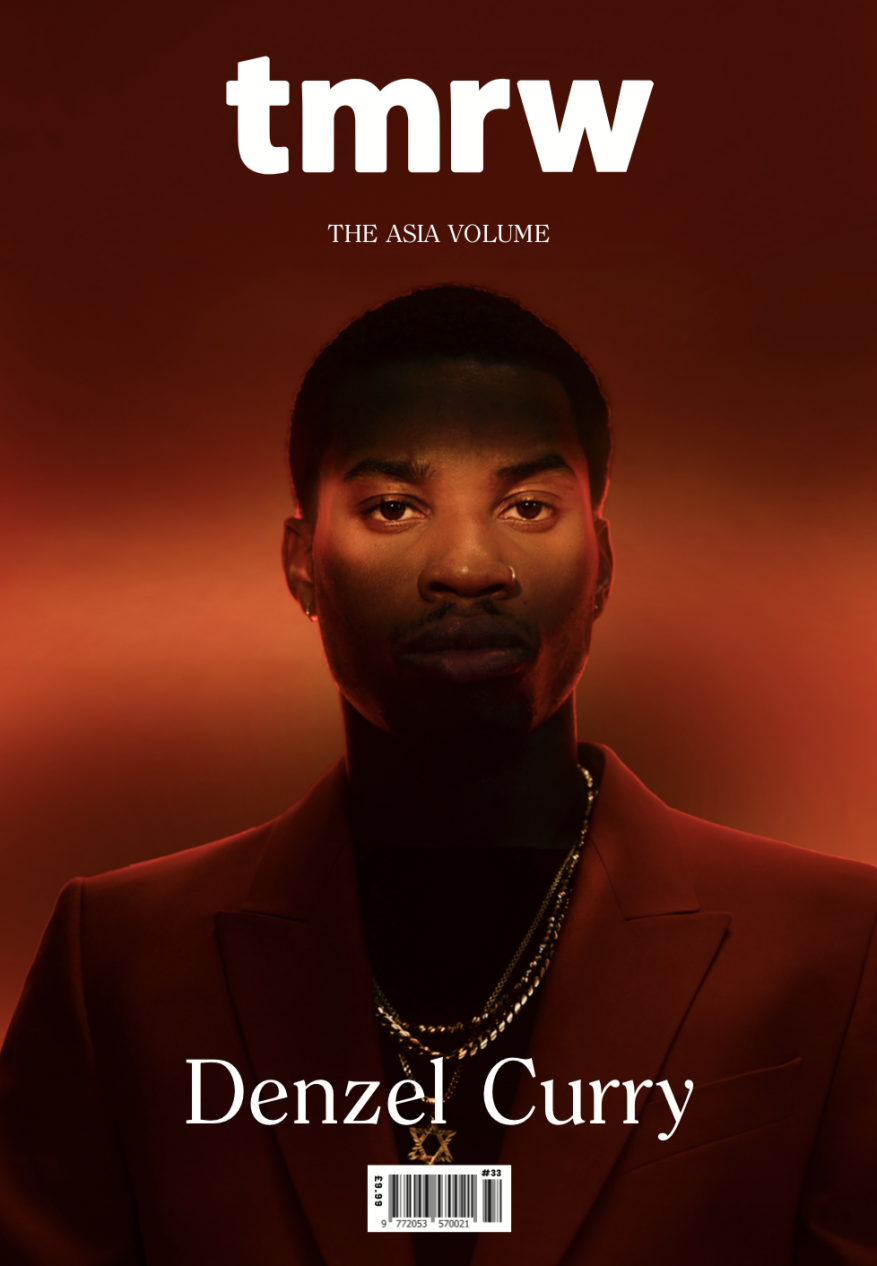 TMRW magazine cover featuring a portrait of Denzel Curry. The magazine has a red background with Denzel Curry wearing a red suit.