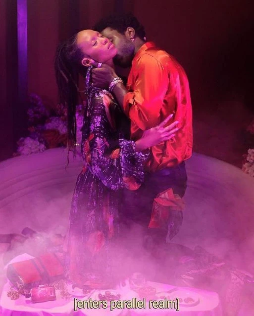 Intimate portrait of a couple in embrace, set in a dreamy, fog-filled space with vibrant floral arrangements and dramatic lighting.