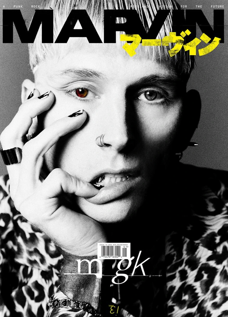Magazine cover featuring a portrait of Machine Gun Kelly with heterochromia, wearing an animal print top, against a grey background.