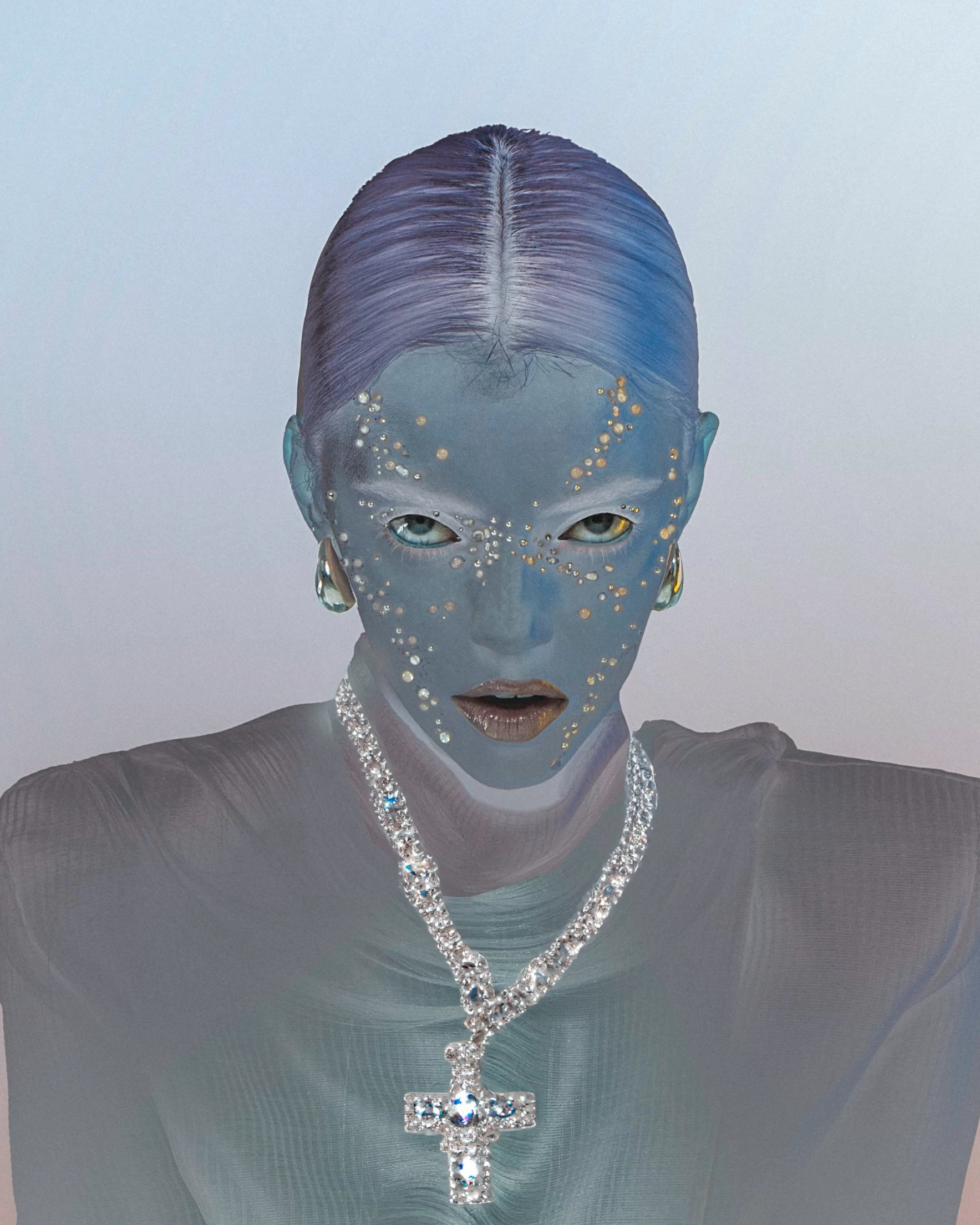 Close-up portrait of a person with blue skin, jewelry, and light-colored eyes against a soft background. Conceptual fashion and beauty.
