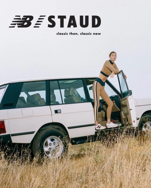 An adult woman in athleisure wear standing by an open SUV door on a grassy field against a bright sky with brand logos overhead.