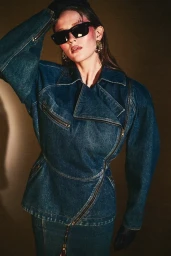 Model wearing dark sunglasses, statement earrings, and an oversized denim jacket styled by Maren Taylor.