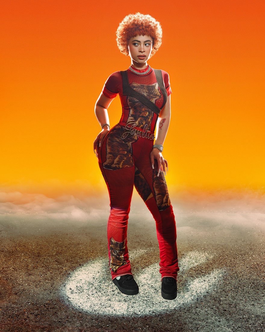 A woman with curly hair poses in a patterned red jumpsuit with black sneakers against an orange and gray textured background.