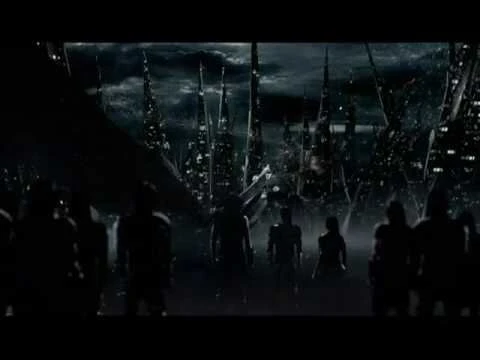 Dark futuristic scene of figures walking toward a metropolis with jagged skyscrapers and a cloudy, stormy sky. 