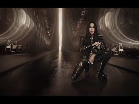Cher in a futuristic, dark, and stylish setting. The pop singer is captured in a crouching pose, wearing a sleek, black outfit with platform shoes.