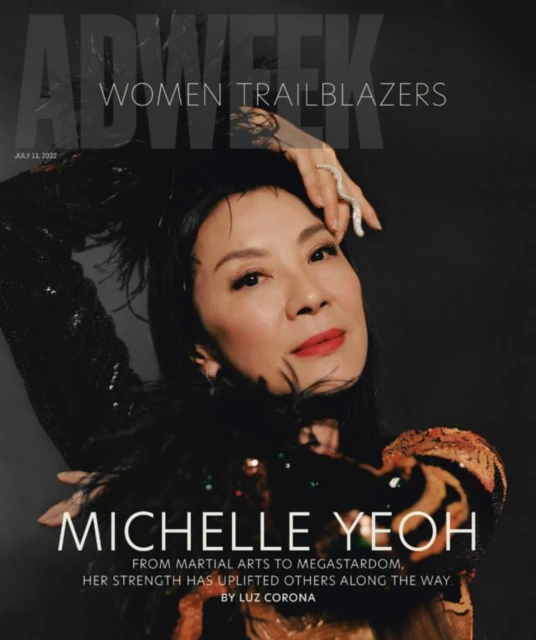 Michelle Yeoh on the cover of AdWeek magazine, a close-up portrait shot against a dark background, featuring a black feathered top.