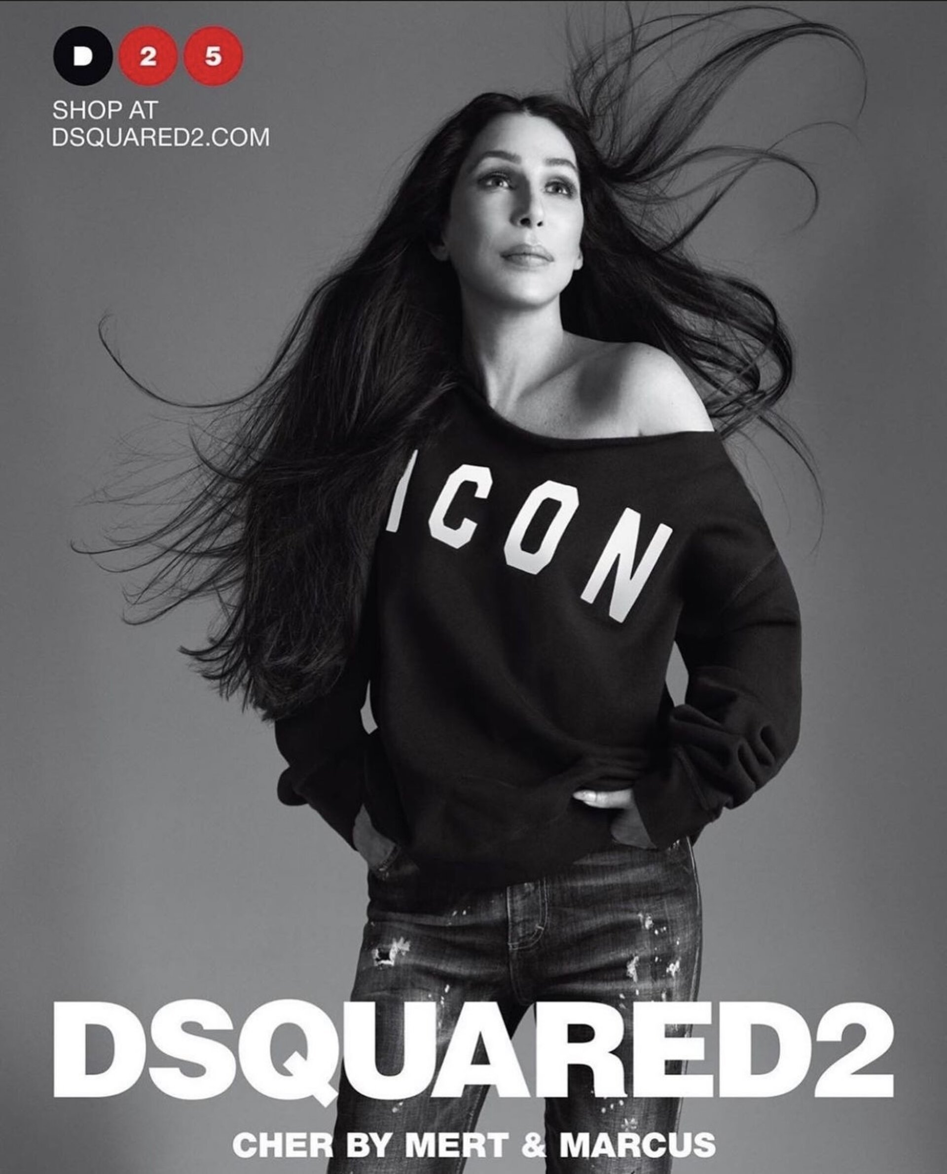 A woman with long, dark hair poses in a black, off-the-shoulder 'ICON' sweatshirt and embellished jeans against a gray background for a Dsquared2 ad.