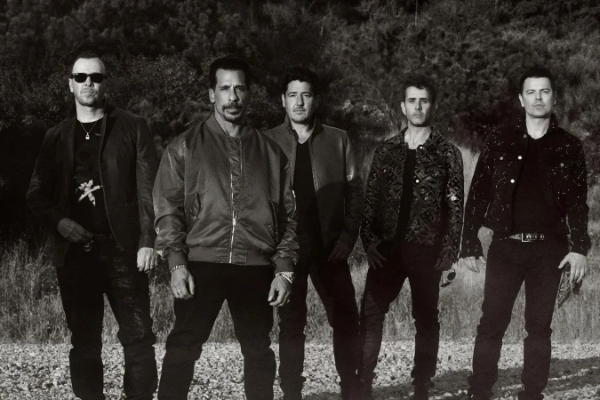 Monochrome portrait of five men standing outdoors in a rocky landscape styled by Marjan Malakpour