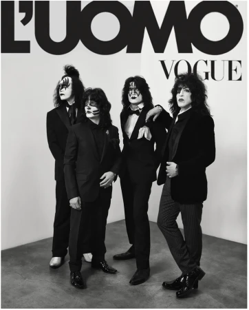 Four people in black suits with theatrical makeup pose in a studio, reminiscent of the rock band KISS, for L'Uomo Vogue.