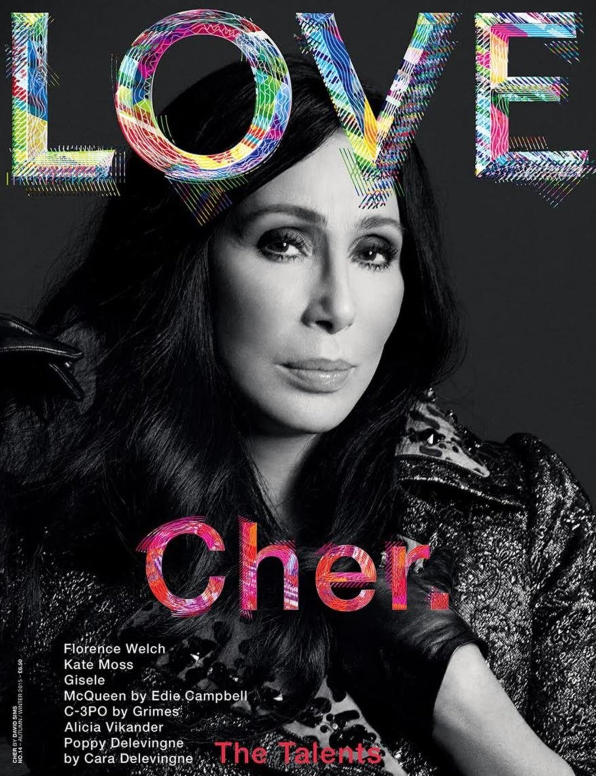 Close-up magazine cover of Cher with 'LOVE' title, featuring dark hair, detailed makeup, and a patterned jacket, emphasizing her portrait.