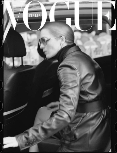 Vogue Italia cover with a woman in a black jacket getting into a car, captured in a black and white photograph with film border.