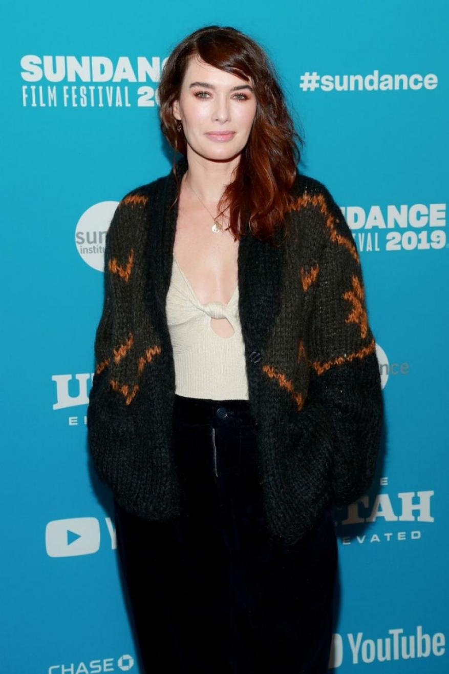 Woman with auburn hair wearing a black cardigan at the Sundance Film Festival stands in front of an event backdrop.