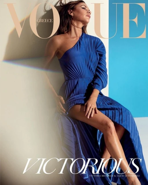 Vogue Greece magazine cover featuring a woman in a blue one-shoulder dress against a two-tone background of beige and light blue.