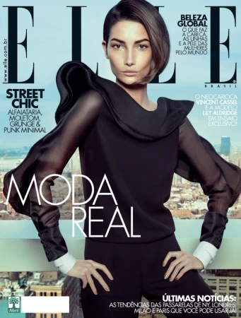 Model Lily Aldridge wearing a black top with sheer sleeves and white cuffs, styled by Mary Fellowes for Elle Brasil.