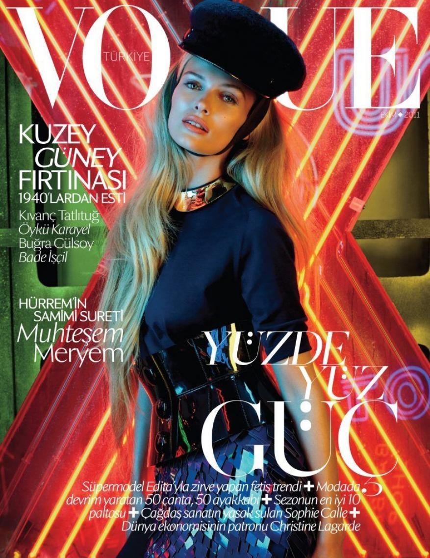 Vogue Türkiye cover features a blonde model wearing a black cap and collar necklace against a vibrant red and green neon background.