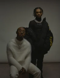 Two men posing against a neutral backdrop, styled by Mecca Cox in Los Angeles.