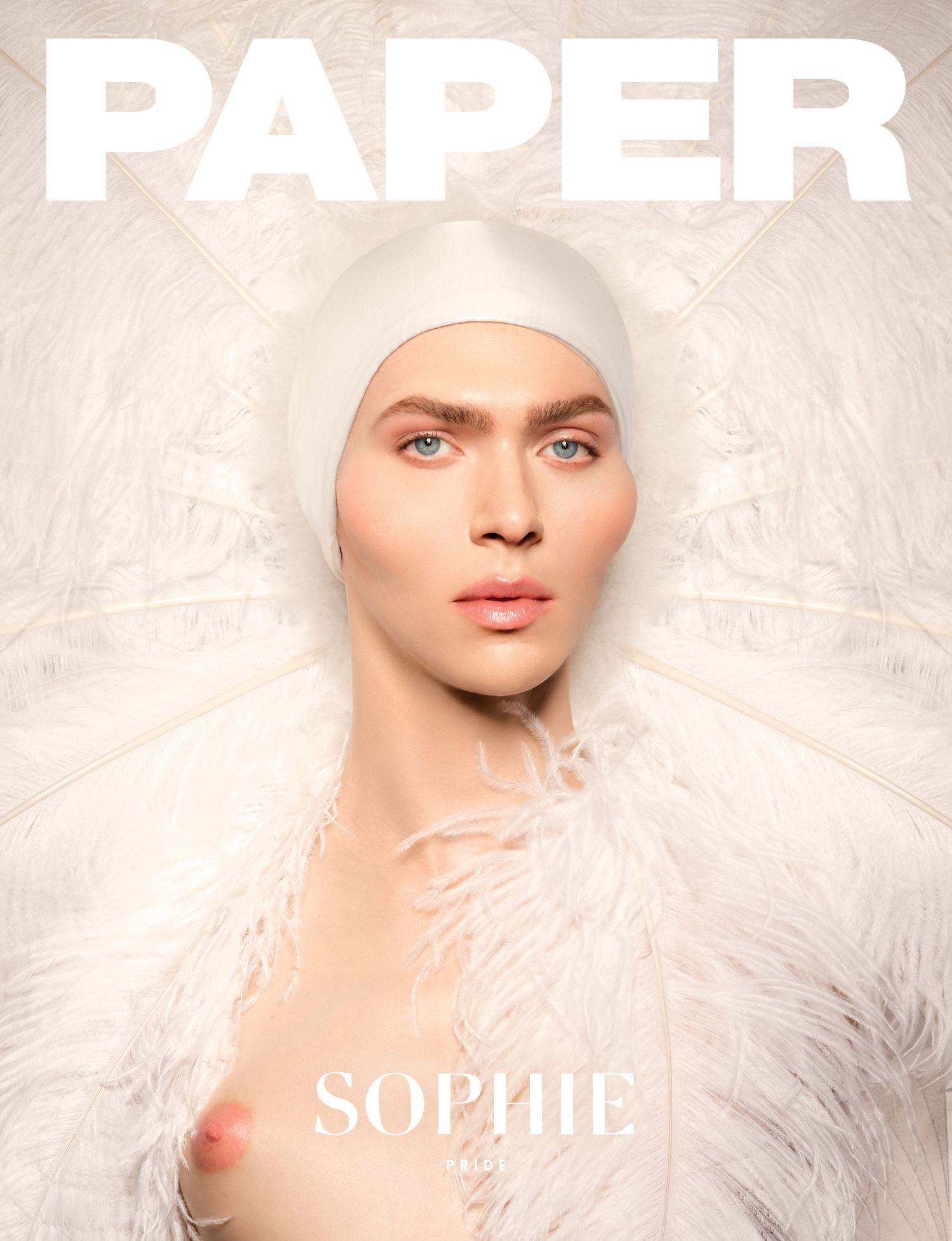 Close-up fashion shot of a bare-chested model with a white head covering, surrounded by white feathers against a bright background.