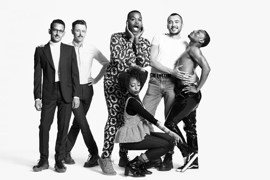 Group studio portrait in black and white featuring six diverse people in casual and formal wear against a bright, neutral background.
