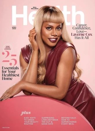 Health magazine cover featuring Laverne Cox wearing a maroon dress, light blonde hair, and a gold ring, set against a light pink background.