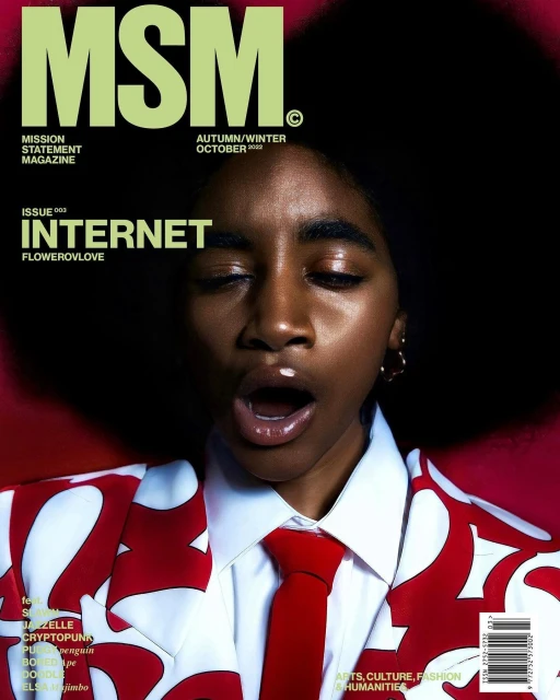 Magazine cover featuring a young adult with an open mouth, wearing a patterned blazer and tie, against a dark red backdrop.