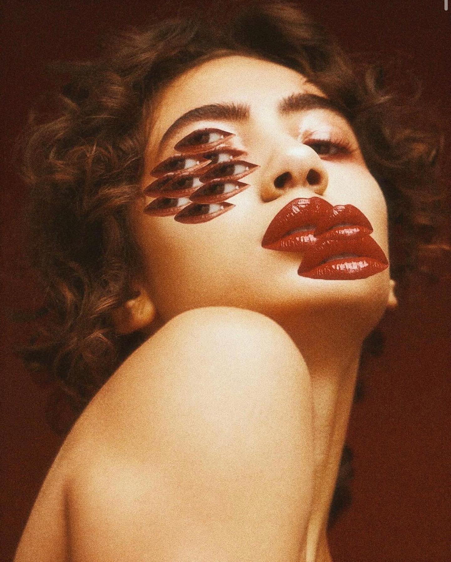 Portrait of a woman with surreal eye and lip makeup against a plain backdrop, creating an artistic and visually striking composition.