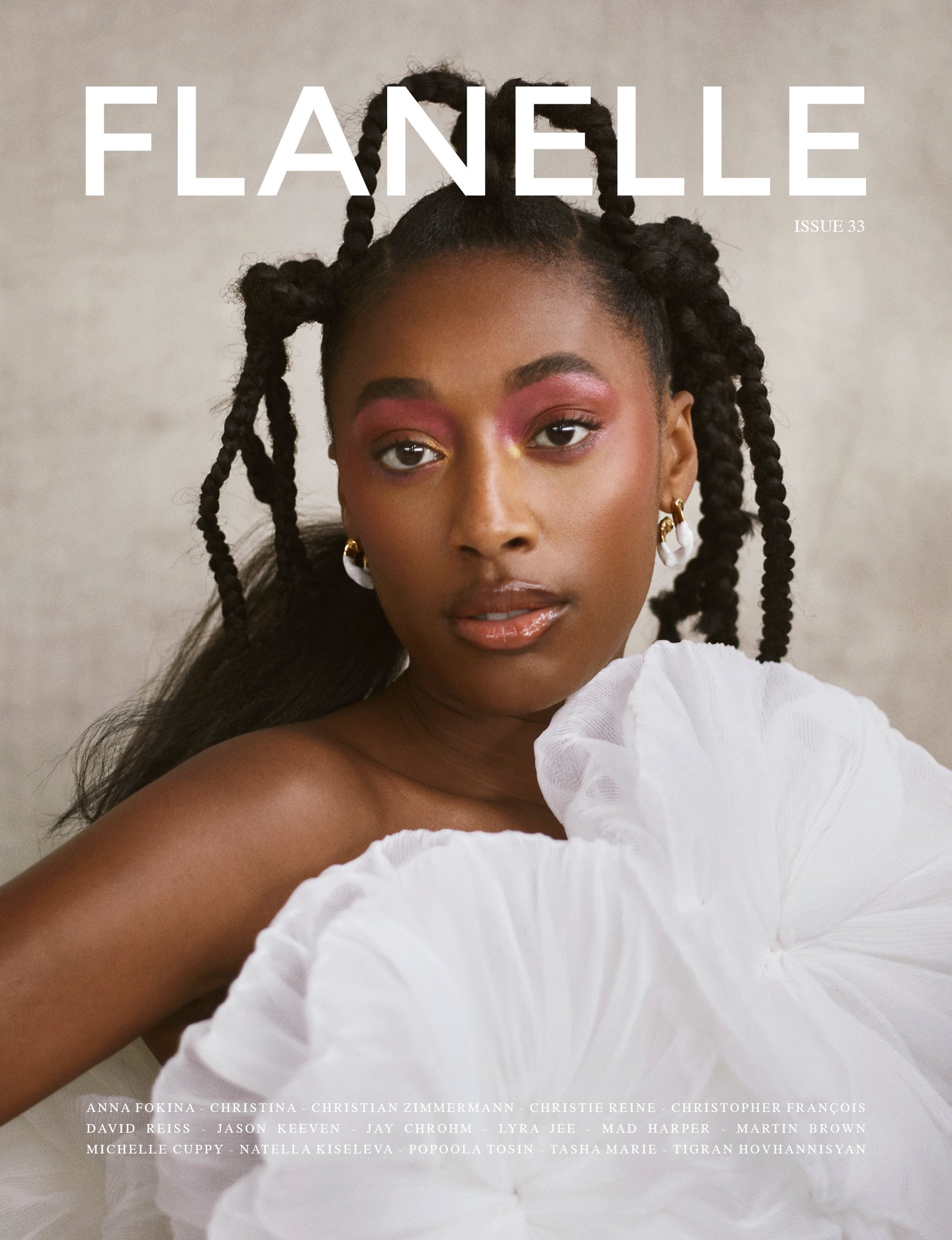 Magazine cover featuring a Black woman with elaborate braided hair, wearing pink eye shadow and a white ruffled top against a grey background.