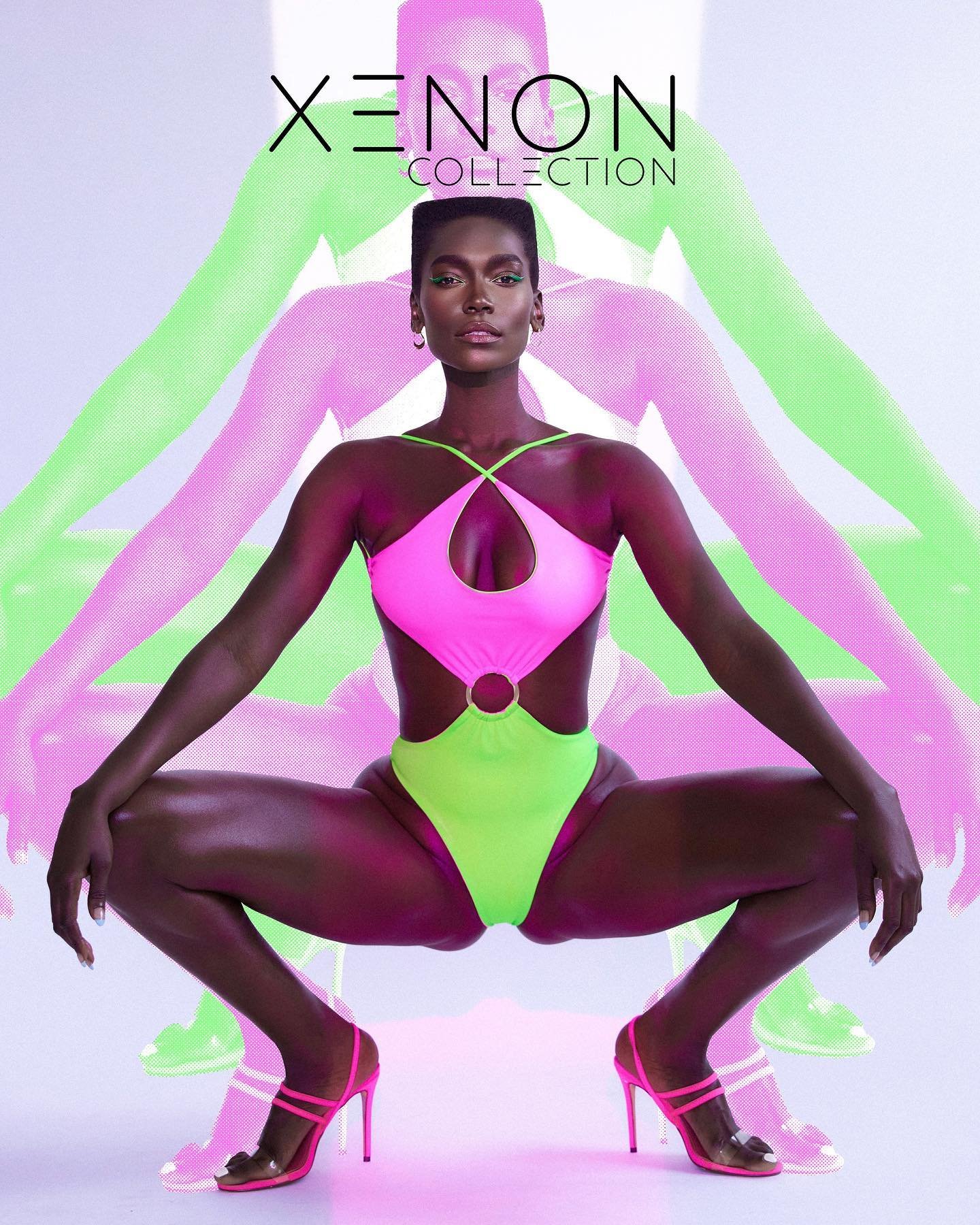 Dark-skinned female model poses in a neon pink and green one-piece swimsuit and high heels against an abstract background.