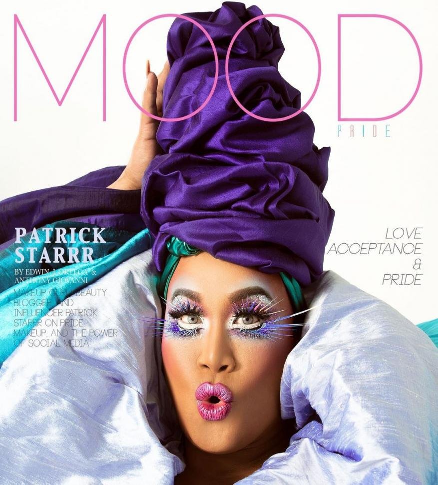 Magazine cover featuring Patrick Starrr with elaborate makeup, a purple headwrap, and oversized white lashes against a bright white background.