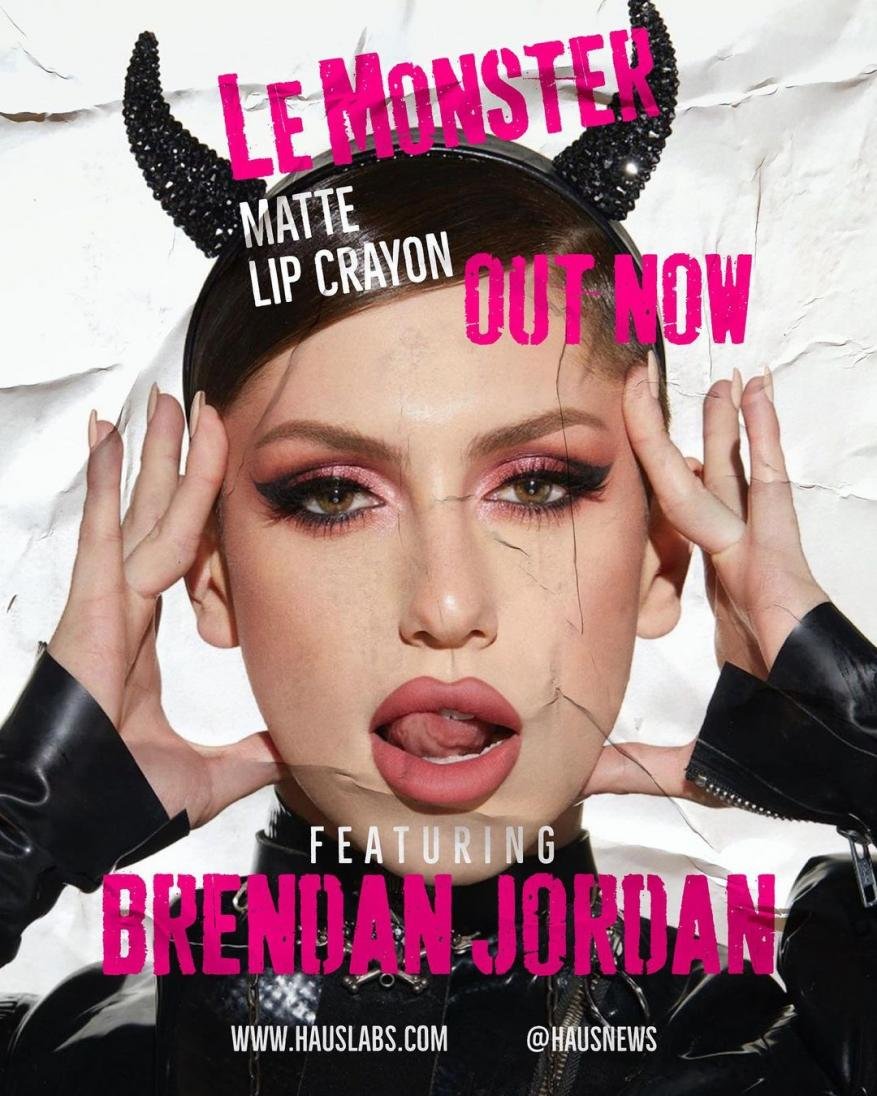 Close-up of model Brendan Jordan wearing dark devil horns and makeup to promote a cosmetic lip crayon with dramatic cracked paper effect.