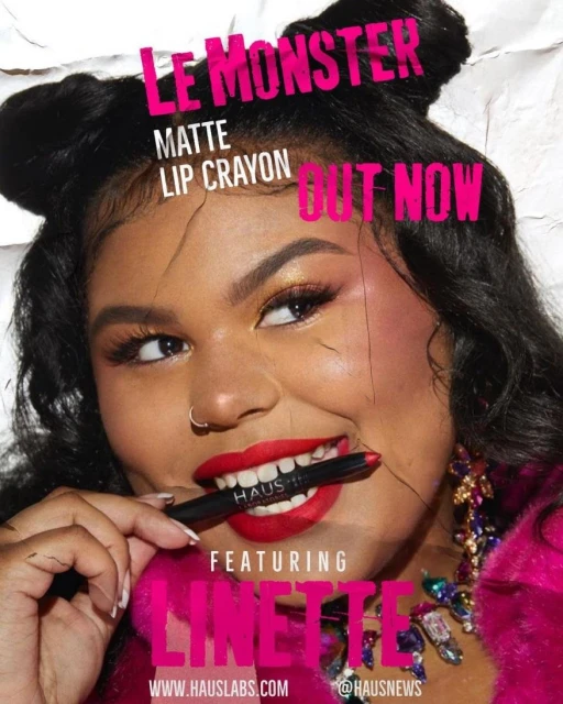 Close-up of an adult female with red lipstick biting a lip crayon, showcasing makeup and beauty for a Haus Labs cosmetic advertisement.