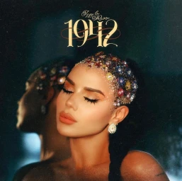 Close-up portrait of a woman with heavily jeweled and glittered hair, wearing peach lipstick and ornate crystal earrings.