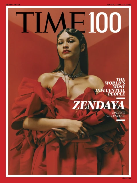 Zendaya graces the TIME 100 cover, wearing a red dress and striking a poised pose against a matching red backdrop for a portrait.