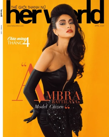 Her World magazine cover featuring a brunette woman in an elegant black dress against a vivid yellow backdrop, April 2023 edition.