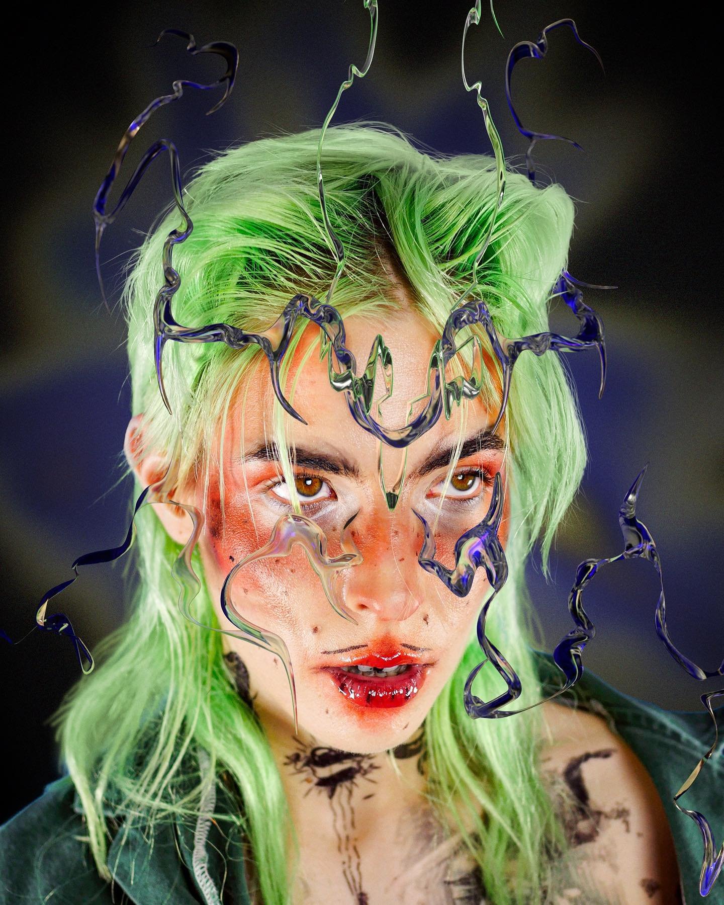 Portrait of person with green hair, elaborate makeup, and sculptural headpiece against a blurred patterned background in an eye-level shot.
