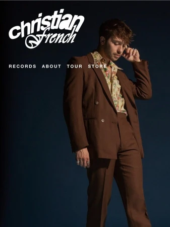 Man in a brown suit standing against a blue background, wearing a floral shirt with text overlay: Christian French Records About Tour Store.