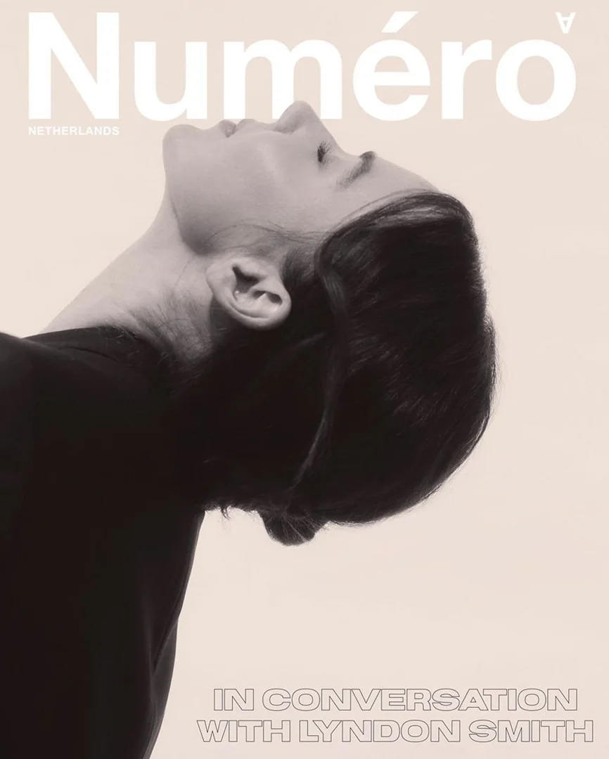 Magazine cover featuring a woman with short hair and a black top, head tilted back, with magazine branding, 'Numéro' in large white text.