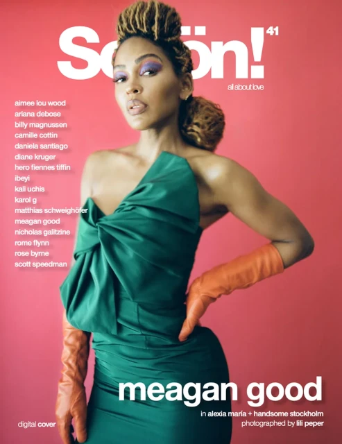 Magazine cover featuring Meagan Good in an emerald dress and orange gloves, set against a vibrant pink backdrop with magazine text.