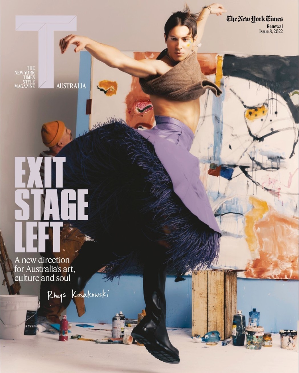 Magazine cover featuring a dancer in avant-garde fashion posing in front of an abstract painting with paint cans in a photo studio.
