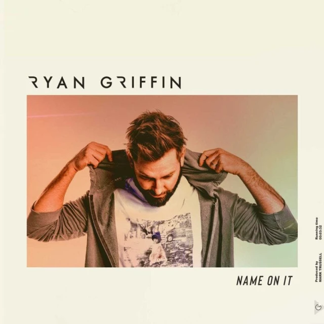 Ryan Griffin's music album cover features the artist indoors wearing a gray hoodie, standing in front of a gradient background.