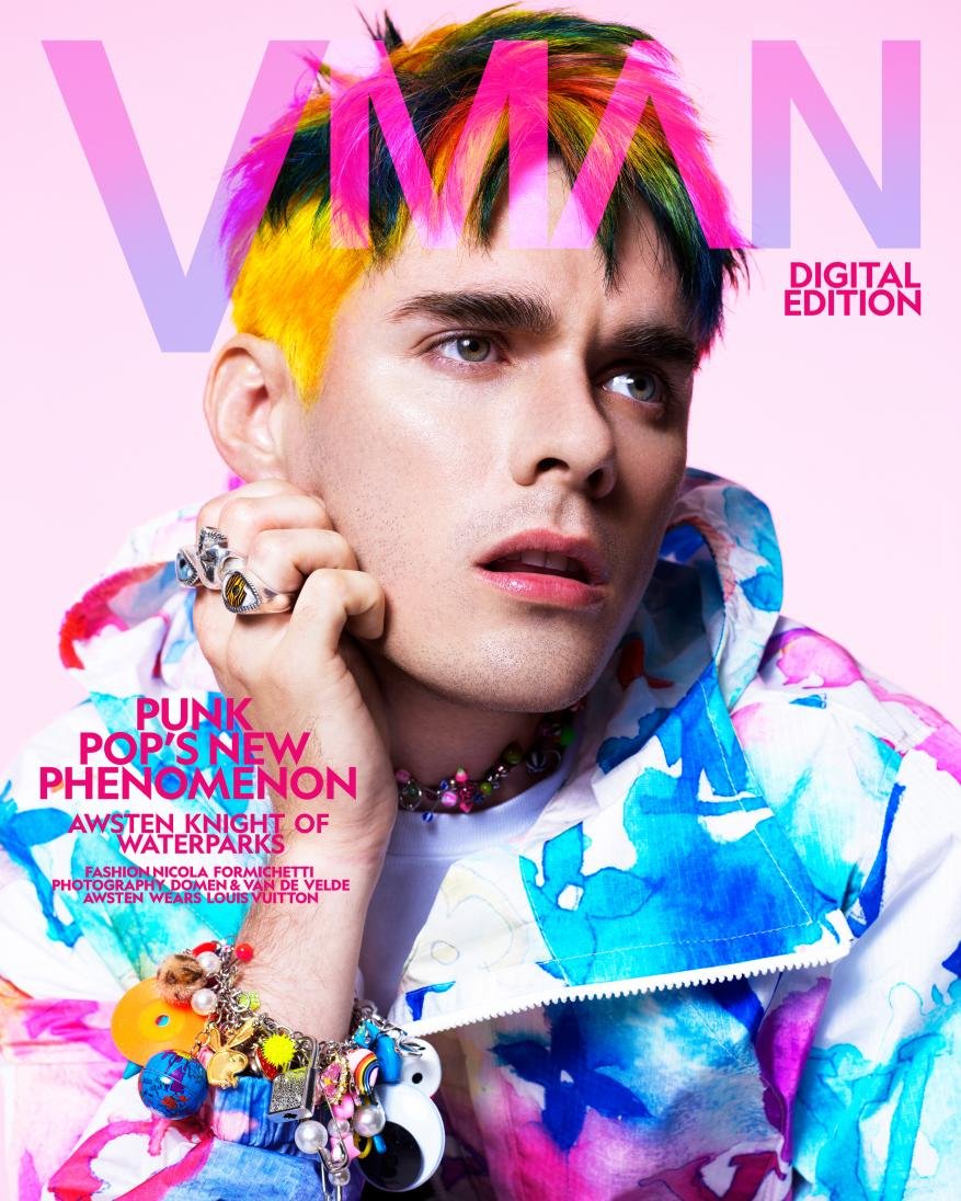 Magazine cover featuring a young adult with colorful hair, wearing a patterned jacket and jewelry, against a pink background with text.