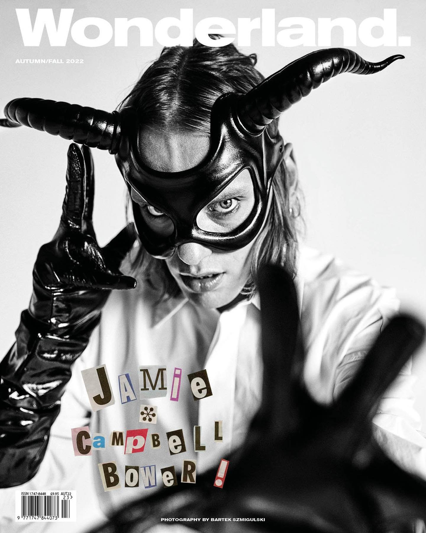 Wonderland magazine cover featuring Jamie Campbell Bower wearing a horned mask and gloves in black and white with cutout text.