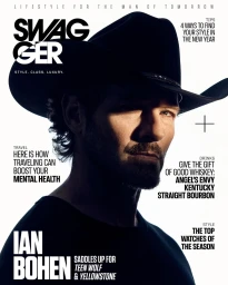 Close-up portrait of actor Ian Bohen wearing a black cowboy hat and dark shirt against a white background