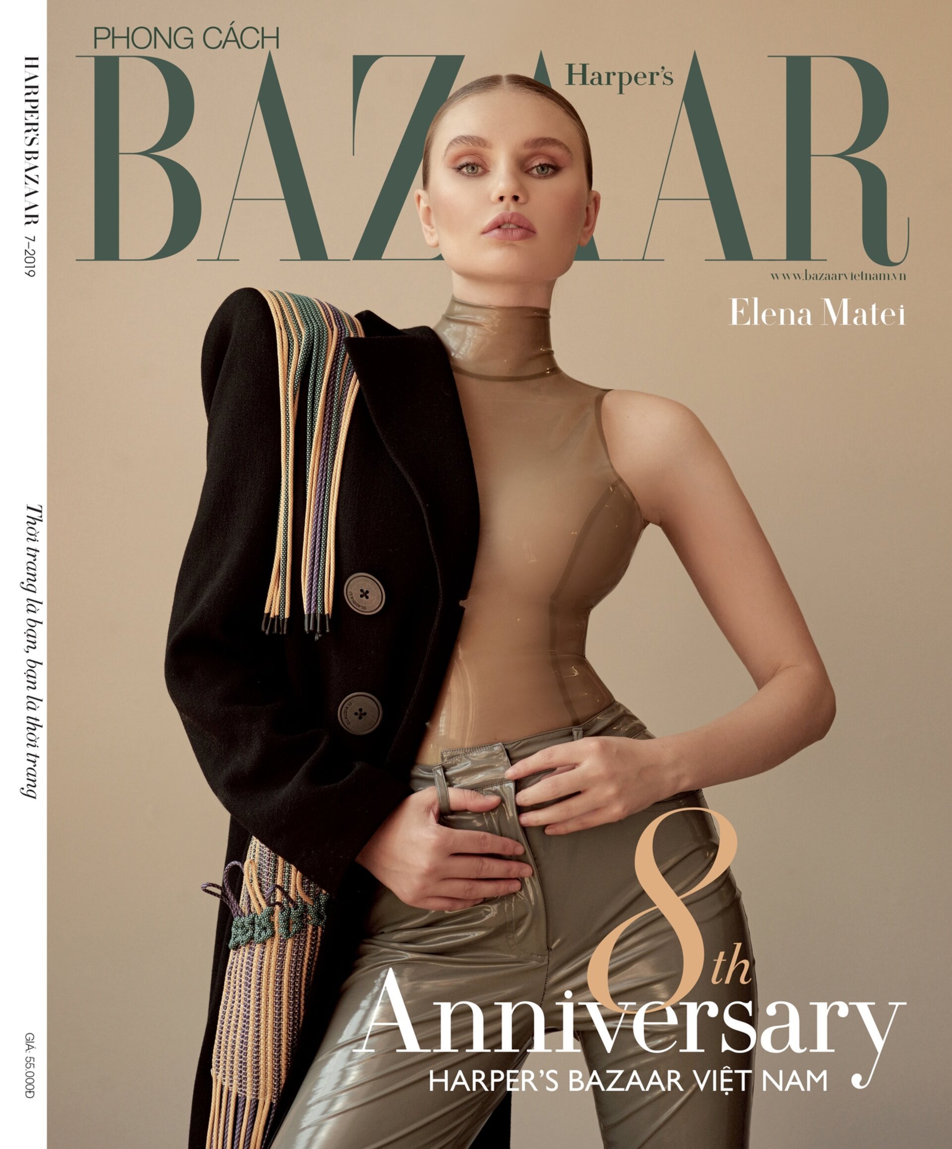 Harper's Bazaar Vietnam cover featuring Elena Matei. Model wears a beige bodysuit and metallic pants, posing with a black coat draped over the shoulder.