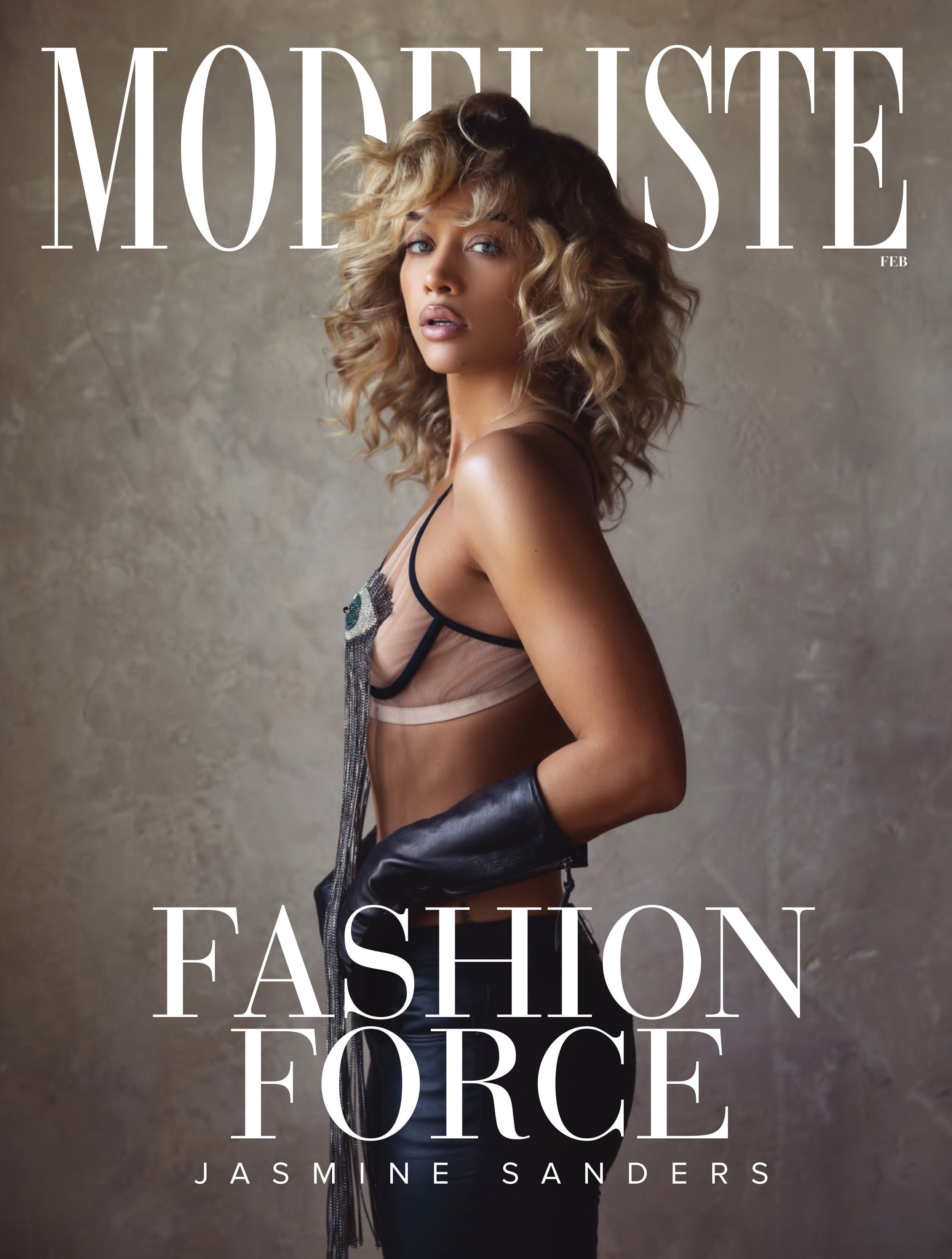 Fashion magazine cover featuring Jasmine Sanders in a black leather glove and decorative top against a muted background.