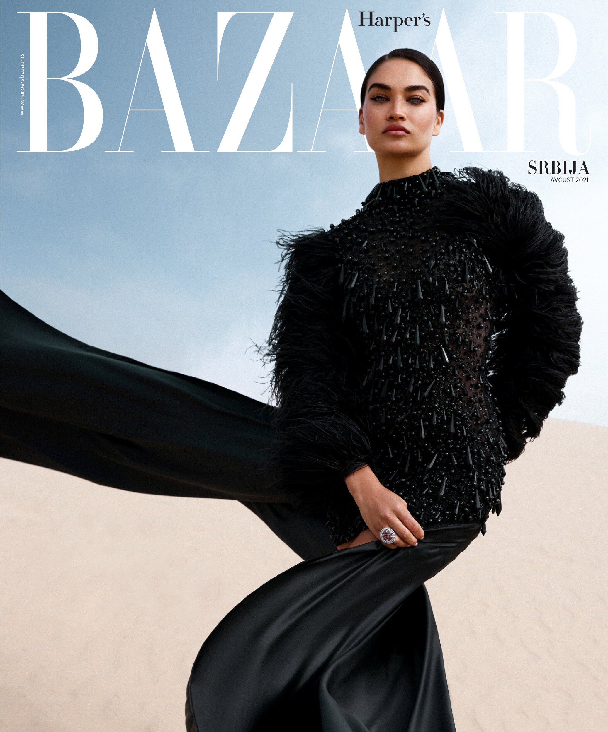Fashion editorial cover featuring an adult female model wearing black embellished couture on a sand dune with Harper's Bazaar logo.