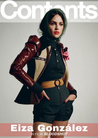 Eiza González on a magazine cover wearing a brown and beige jacket with a black shirt and green headscarf against a gray background.