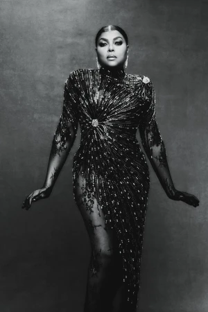 Monochromatic portrait of a woman in a beaded and lace gown, posing against a textured background in a studio setting.