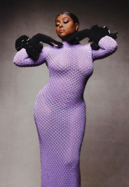 A full-length portrait of an African-American woman wearing a lavender dress with black gloves, posing in front of a grey backdrop.