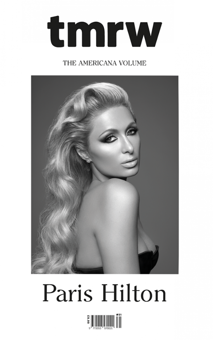 Black-and-white magazine cover featuring Paris Hilton with blonde hair, dark eye makeup, and a strapless dress on a grey backdrop.