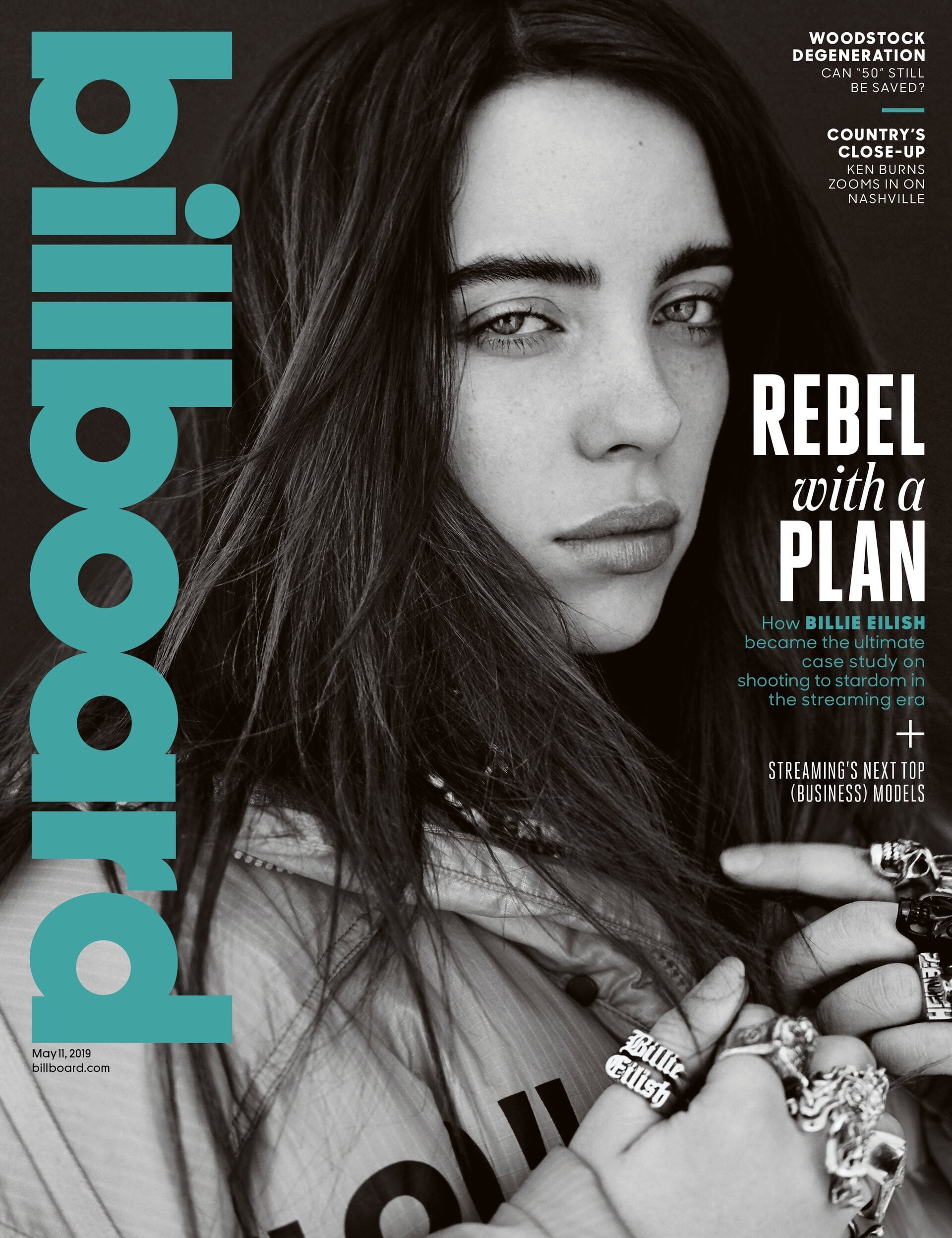 Billboard magazine cover featuring a close-up of Billie Eilish looking at the camera, wearing rings and a jacket. Billboard logo is prominent.